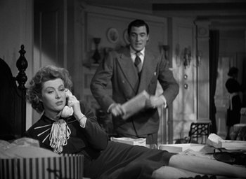 Movie still from “Mrs. Miniver” (1942), directed by William Wyler – A man and a woman are sitting on a couch; Medium shot, Low angle