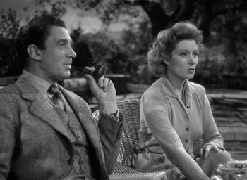 Movie still from “Mrs. Miniver” (1942), directed by William Wyler – A man and a woman sitting on a bench; Medium shot, High angle