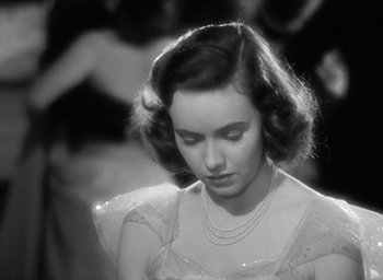 Movie still from “Mrs. Miniver” (1942), directed by William Wyler – An old photo of a woman in a dress looking down; Close Up shot, High angle