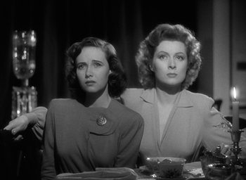 Movie still from “Mrs. Miniver” (1942), directed by William Wyler – A couple of women sitting next to each other at a table; Close Up shot, Low angle