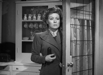 Movie still from “Mrs. Miniver” (1942), directed by William Wyler – A woman holding a cell phone standing in front of a door; Medium shot, Low angle