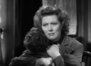 Movie still from “Mrs. Miniver” (1942), directed by William Wyler – An old photo of a woman holding a child in her arms; Close Up shot, Over the shoulder angle