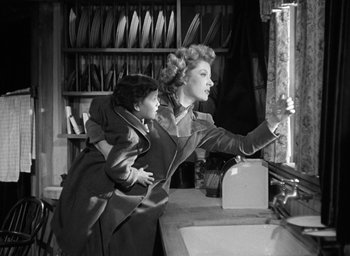 Movie still from “Mrs. Miniver” (1942), directed by William Wyler – A woman and a little girl are in a kitchen; Medium shot, High angle