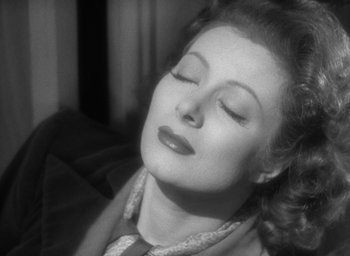 Movie still from “Mrs. Miniver” (1942), directed by William Wyler – An old photo of a woman with her eyes closed; Close Up shot, High angle
