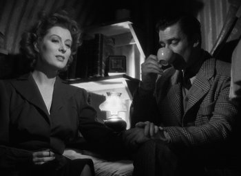 Movie still from “Mrs. Miniver” (1942), directed by William Wyler – A man and a woman sitting on a couch drinking wine; Medium shot, Low angle