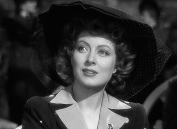 Movie still from “Mrs. Miniver” (1942), directed by William Wyler – An old photo of a woman with a black hat; Close Up shot, Low angle