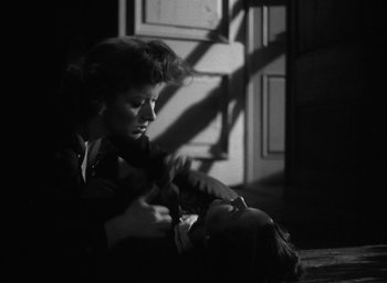 Movie still from “Mrs. Miniver” (1942), directed by William Wyler – A woman sitting on the ground with a child; Close Up shot, High angle