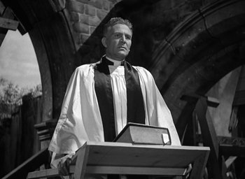 Movie still from “Mrs. Miniver” (1942), directed by William Wyler – A man standing at a lectern in front of an altar; Medium shot, Low angle