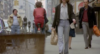 Movie still from “Ms .45” (1981), directed by Abel Ferrara – A woman walking down the street with a child on a bike; Wide shot, Low angle