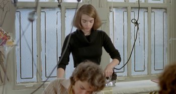 Movie still from “Ms .45” (1981), directed by Abel Ferrara – A woman in a black shirt is ironing a shirt; Medium shot, High angle