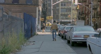Movie still from “Ms .45” (1981), directed by Abel Ferrara – A man walking down a street with a woman walking down the sidewalk; Wide shot, High angle