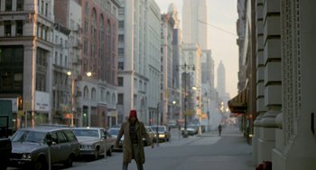 A man is walking down the street in the city
