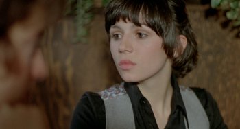 Movie still from “Ms .45” (1981), directed by Abel Ferrara – A woman with short brown hair wearing a black shirt; Close Up shot, Over the shoulder angle