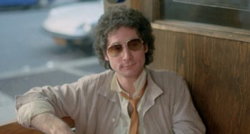 Movie still from “Ms .45” (1981), directed by Abel Ferrara – A man with curly grey hair wearing sunglasses and a tie; Close Up shot, Low angle