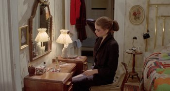 A woman sitting at a desk in front of a mirror