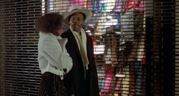Movie still from “Ms .45” (1981), directed by Abel Ferrara – A man and a woman standing next to each other in front of a window; Medium shot, Over the shoulder angle