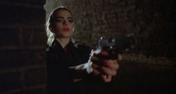 Movie still from “Ms .45” (1981), directed by Abel Ferrara – A woman holding a gun while standing next to a brick wall; Close Up shot, Low angle