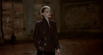 Movie still from “Ms .45” (1981), directed by Abel Ferrara – A woman in a black jacket standing in a dark place; Medium shot, Low angle