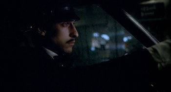 Movie still from “Ms .45” (1981), directed by Abel Ferrara – A man wearing a hat sitting in the driver's seat of a car at night; Close Up shot, Low angle