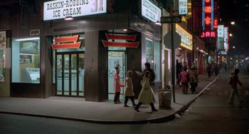 Two women and a child walking down the street at night