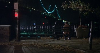 Movie still from “Ms .45” (1981), directed by Abel Ferrara – Two people sitting on a bench in front of a bridge at night; Extreme Wide shot, High angle