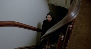 Movie still from “Ms .45” (1981), directed by Abel Ferrara – A woman in a black hooded top standing at the top of a staircase; Medium shot, High angle