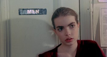 Movie still from “Ms .45” (1981), directed by Abel Ferrara – A young woman in front of a men sign; Close Up shot, Low angle