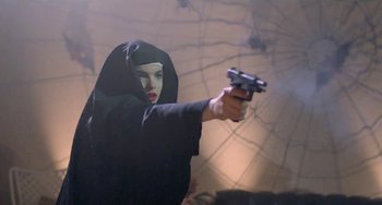 Movie still from “Ms .45” (1981), directed by Abel Ferrara – A woman dressed as a nun holding a gun; Medium shot, Low angle