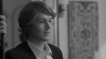 Movie still from “Much Ado About Nothing” (2012), directed by Joss Whedon – Black and white photograph of a young man in a suit; Close Up shot, Over the shoulder angle