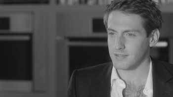 Movie still from “Much Ado About Nothing” (2012), directed by Joss Whedon – Black and white photograph of a man in a suit; Close Up shot, Over the shoulder angle