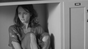 Movie still from “Much Ado About Nothing” (2012), directed by Joss Whedon – Black and white photograph of a woman sitting on a shelf; Medium shot, Low angle