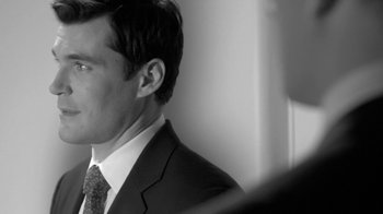 Movie still from “Much Ado About Nothing” (2012), directed by Joss Whedon – Black and white photograph of a man wearing a suit and tie; Close Up shot, Over the shoulder angle