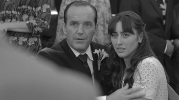 Movie still from “Much Ado About Nothing” (2012), directed by Joss Whedon – A man and a woman posing for a picture; Close Up shot, Over the shoulder angle