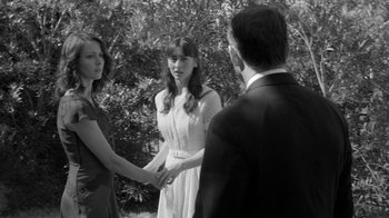 Movie still from “Much Ado About Nothing” (2012), directed by Joss Whedon – Two women and a man standing in front of a tree; Medium shot, Over the shoulder angle
