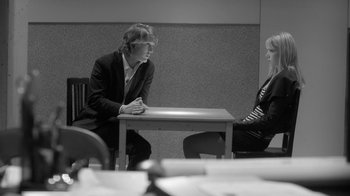 Movie still from “Much Ado About Nothing” (2012), directed by Joss Whedon – A man and a woman sitting at a table; Medium shot, Over the shoulder angle