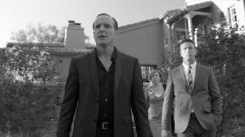 Movie still from “Much Ado About Nothing” (2012), directed by Joss Whedon – A black and white photo of a man and two women; Medium shot, Low angle