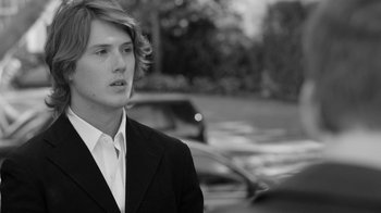 Movie still from “Much Ado About Nothing” (2012), directed by Joss Whedon – Black and white photograph of a young man in a suit; Close Up shot, Low angle