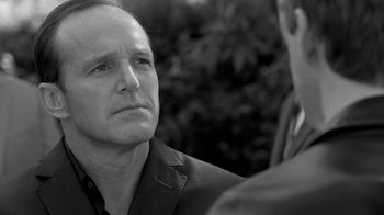 Movie still from “Much Ado About Nothing” (2012), directed by Joss Whedon – Black and white photograph of a man looking at something; Close Up shot, Over the shoulder angle