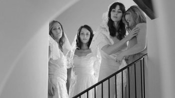 Movie still from “Much Ado About Nothing” (2012), directed by Joss Whedon – A group of young women standing next to each other on stairs; Medium shot, Low angle