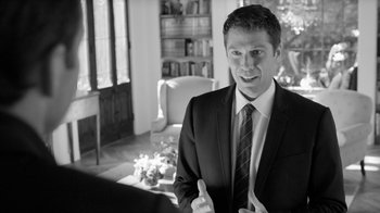 Movie still from “Much Ado About Nothing” (2012), directed by Joss Whedon – Black and white photograph of a man in a suit and tie; Medium shot, Over the shoulder angle