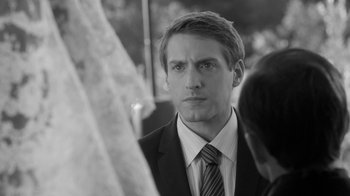 Movie still from “Much Ado About Nothing” (2012), directed by Joss Whedon – Black and white photograph of a man in a suit and tie; Close Up shot, Over the shoulder angle