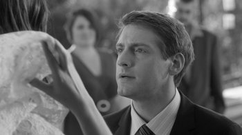 Movie still from “Much Ado About Nothing” (2012), directed by Joss Whedon – A black and white photo of a man holding a cigarette; Close Up shot, Over the shoulder angle