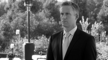 Movie still from “Much Ado About Nothing” (2012), directed by Joss Whedon – Black and white photograph of a man wearing a suit and tie; Close Up shot, Over the shoulder angle