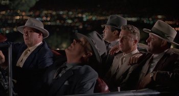 Movie still from “Mulholland Falls” (1996), directed by Lee Tamahori – A group of men sitting next to each other on a bench; Wide shot, High angle
