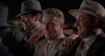 Movie still from “Mulholland Falls” (1996), directed by Lee Tamahori – A group of men standing next to each other in suits; Medium shot, Low angle