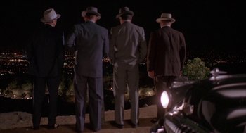 Movie still from “Mulholland Falls” (1996), directed by Lee Tamahori – A group of men standing on top of a hill at night; Wide shot, High angle