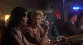Movie still from “Mulholland Falls” (1996), directed by Lee Tamahori – Two women are sitting at a table in front of each other; Medium shot, Over the shoulder angle