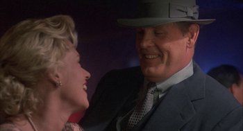 Movie still from “Mulholland Falls” (1996), directed by Lee Tamahori – A man and a woman smiling at each other; Close Up shot, Over the shoulder angle