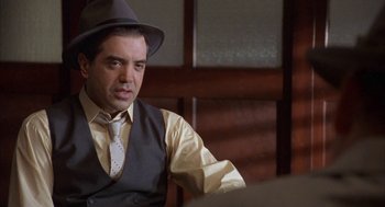 Movie still from “Mulholland Falls” (1996), directed by Lee Tamahori – A man wearing a hat and a tie; Medium shot, Over the shoulder angle