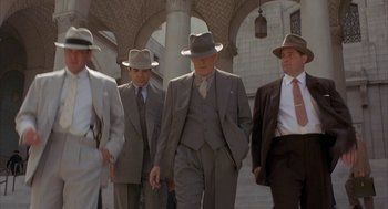 Movie still from “Mulholland Falls” (1996), directed by Lee Tamahori – A group of men in suits and hats walking down a street; Wide shot, Low angle